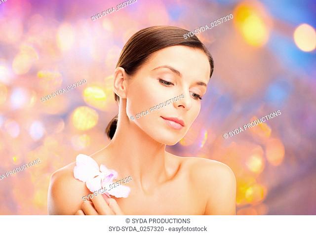 woman with orchid flower over green background