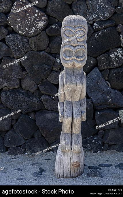 Wooden guardian figure Tiki in front of lava stone wall, Pu'uhonua O Honaunau National Historical Park, Big Island, Hawaii