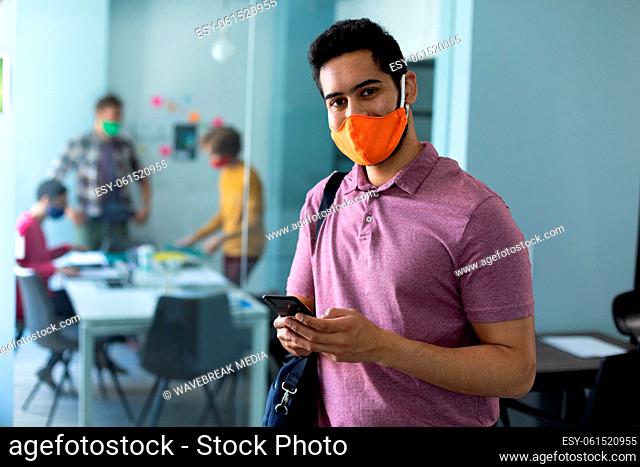 Caucasian man wearing face mask in an office
