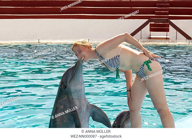 Cuba, Santiago de Cuba, Acuario de Baconao, woman kissed by dolphin