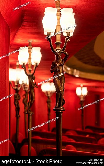 Glimpse of the boxes of the Teatro Manzoni, covered with red velvet upholstery and detail of the Cariatidi lamps made of bronze