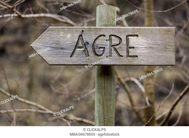 Wooden table with the direction to the village Agre (Le Agre), the site of a ancient hospice and some buildings of a farm