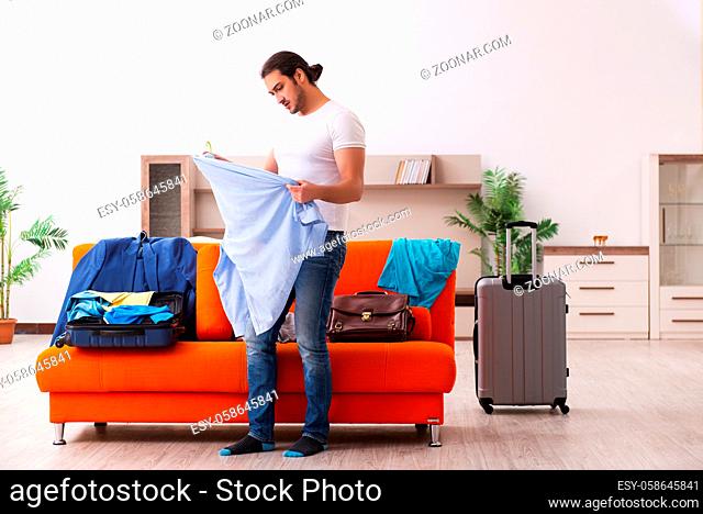 Young male student preparing for trip at home