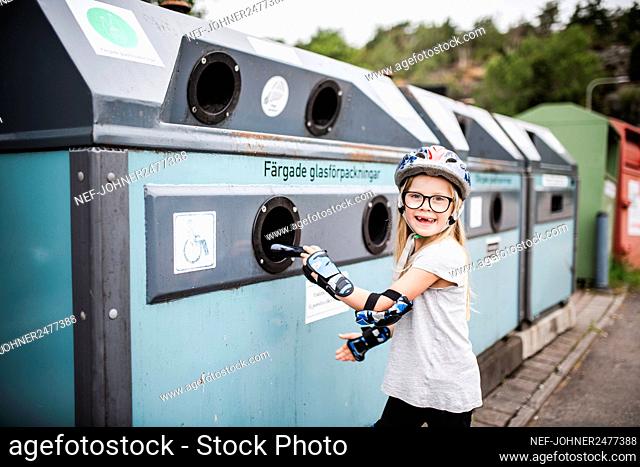 Girl putting rubbish into recycling bin
