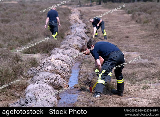 24 April 2020, North Rhine-Westphalia, Niederkrüchten: Firemen are working in the forest on a moat. Several days after the outbreak of a large-scale forest fire...