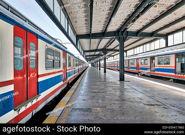 Interior shot of Haydarpasha Railway Terminal featuring metal truss and two colored stopped trains, Kadikoy, Istanbul, Turkey