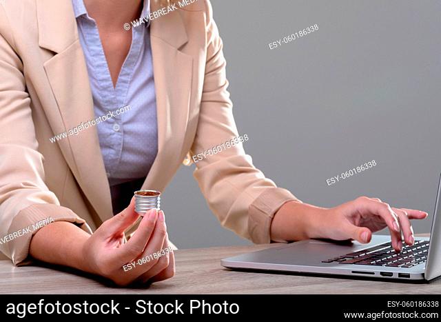 Midsection of caucasian businesswoman holding base of light bulb, isolated on grey background