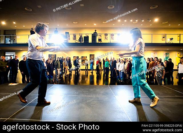 05 November 2022, Berlin: Claire Chen and Fabian Brunner, both dance instructors, lead a free swing or Lindy Hop dance class for warm-up dancing in the foyer of...