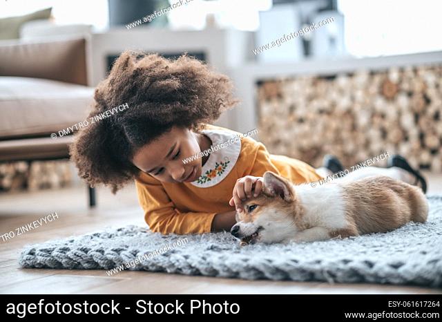 A girl and a puppy. A cute girl playing with the puppy