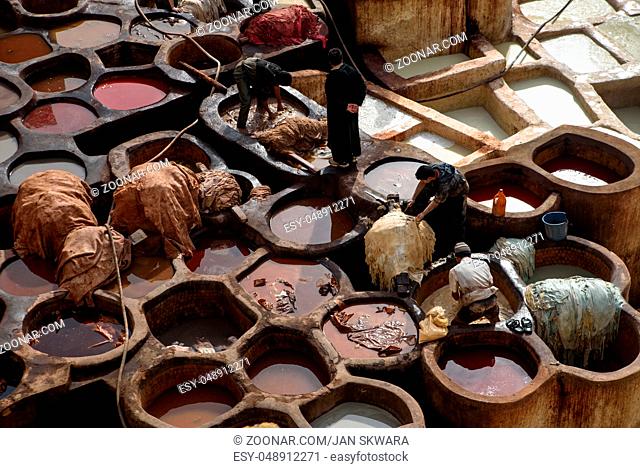 Men working in the Chouara Tannery in the middle of souk in Fez, Morocco. Traditional leather tannery from the 11th century is now biggest tourits attraction in...