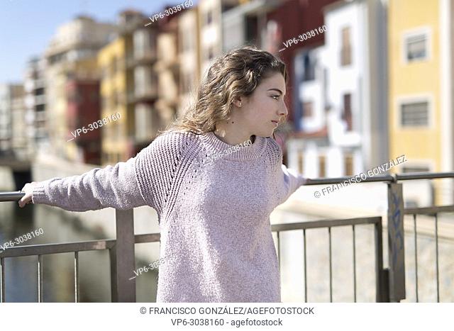 Teen girl resting on a railing in the Spanish city of Orihuela. Horizontal shot with natural light