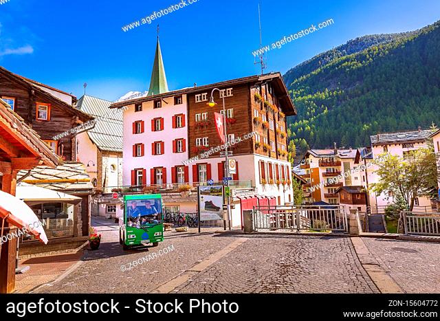 Zermatt, Switzerland - October 7, 2019: Town street view in famous Swiss Alps ski resort, electric car