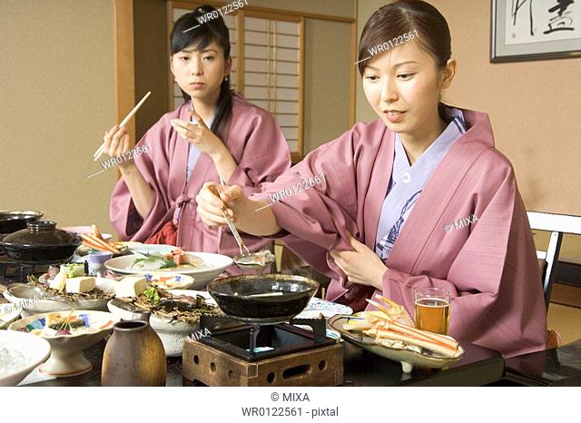 Two young women eating dinner in Japanese style inn