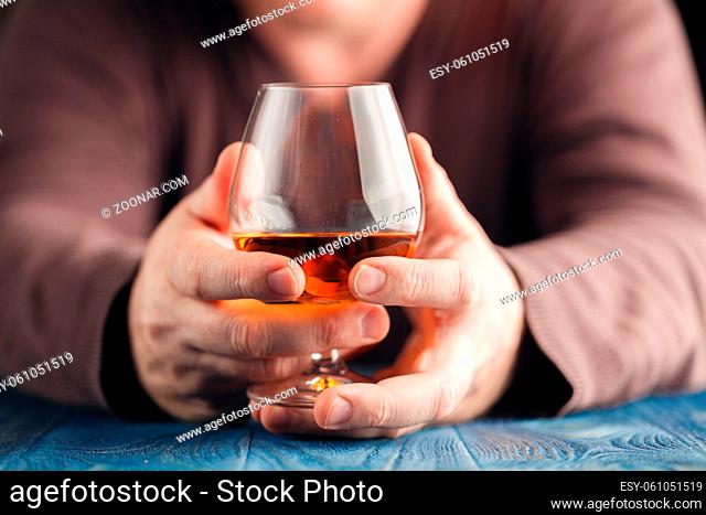 Man abusing alcohol for relaxing, whisky in glass
