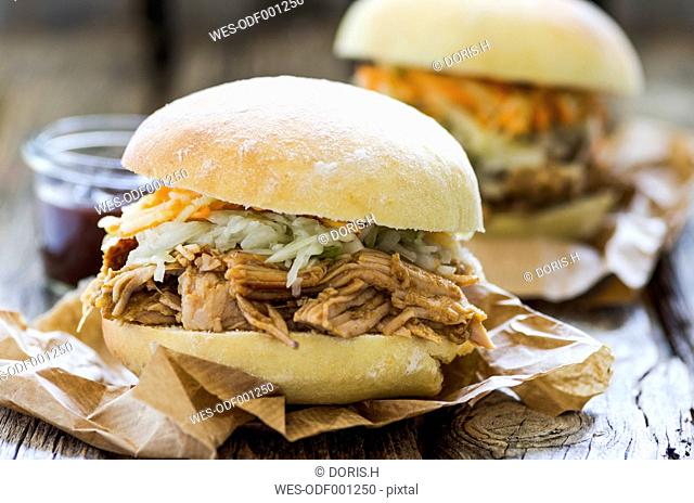 Homemade pulled pork with carrot and cabbage salad on hamburger bun