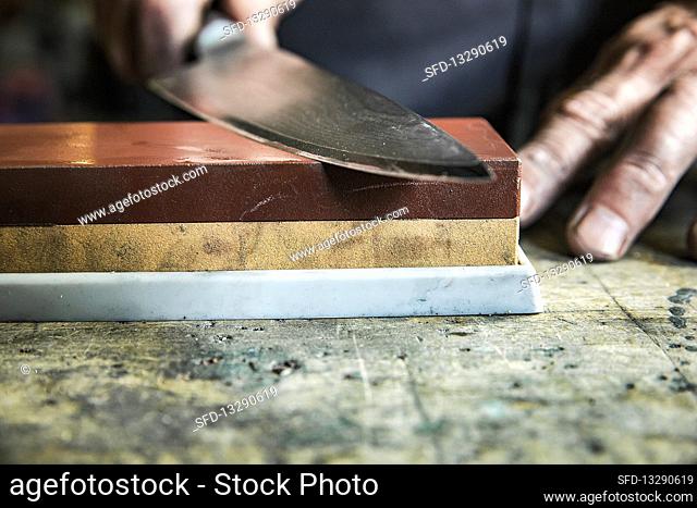 A knife being sharpened on a whetstone