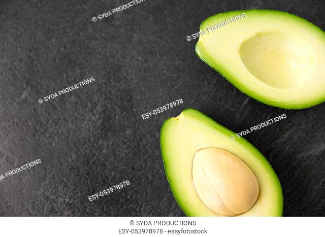 close up of ripe avocado on slate stone background