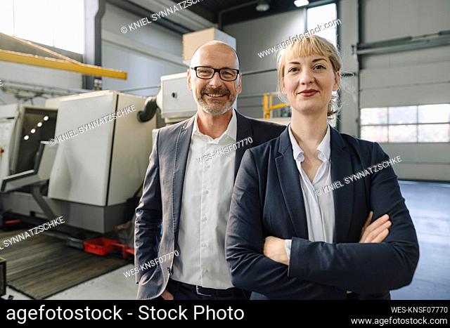 Portrait of confident businessman and businesswoman in a factory