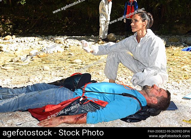 21 August 2020, Bavaria, Berchtesgaden: The actress Genoveva Mayer (r, forensic scientist Sonja Bitterling) with the ""corpse"" of the crashed paraglider taken...