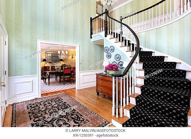 Foyer in luxury home with carpeted staircase
