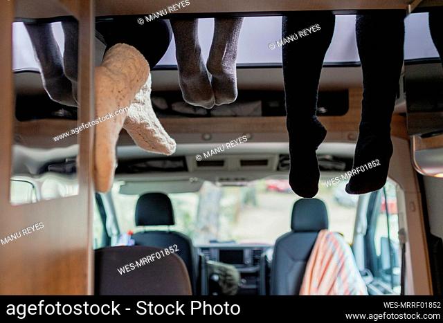 Friends wearing socks hanging legs in motor home
