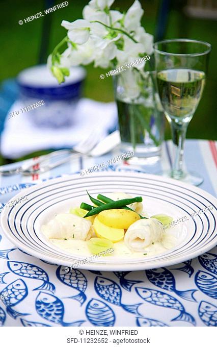 Sole in a creamy sauce with grapes served with potatoes and green beans