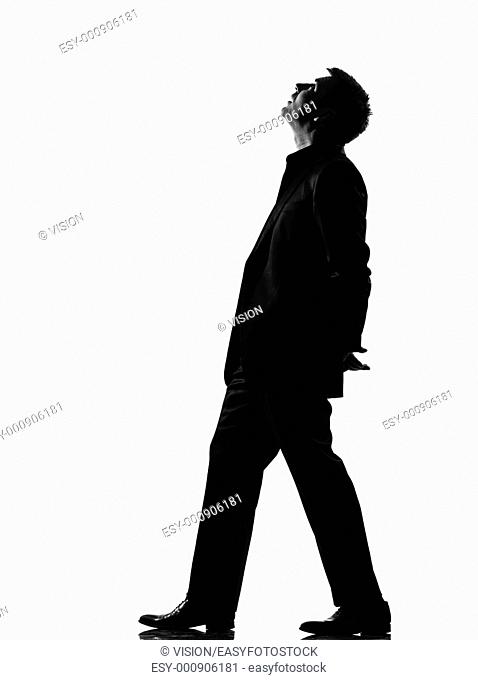 silhouette caucasian business man walking musing looking up expressing behavior full length on studio isolated white background