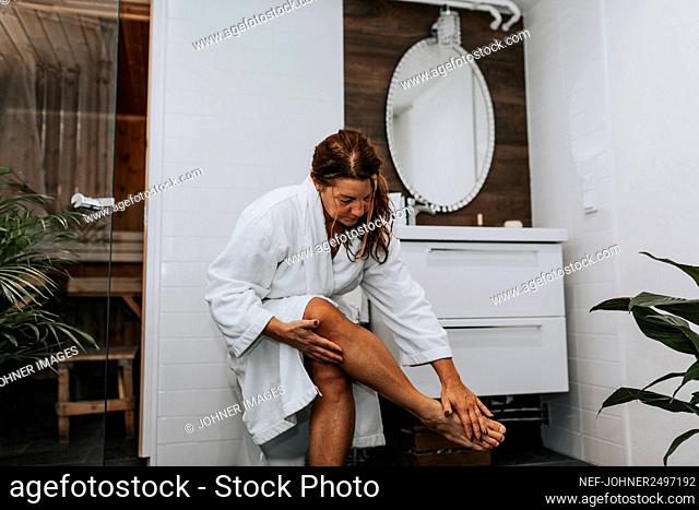 Woman in bathroom applying cream