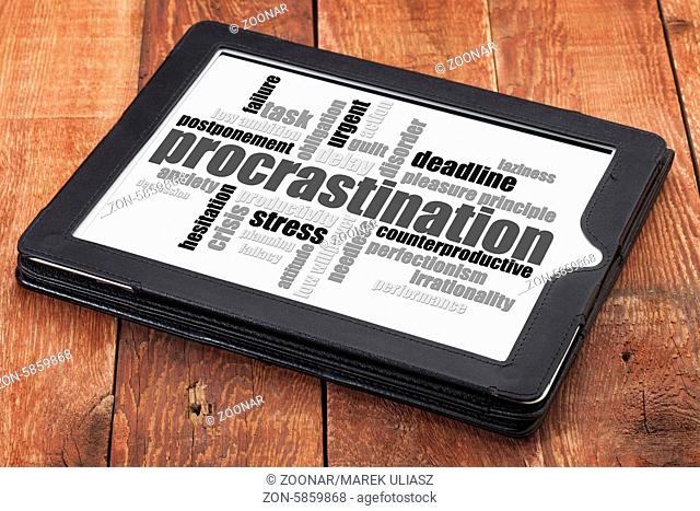 procrastination word cloud on a digital tablet against red barn wood