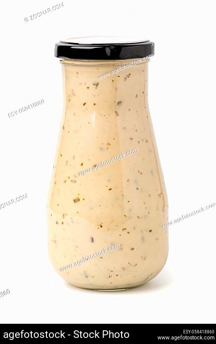 Closed glass jar of white garlic and herb sauce. Isolated on white background