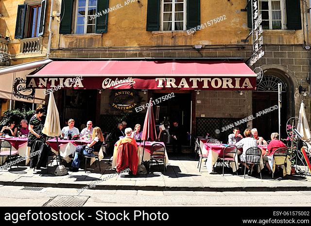 People sitting on the terrace of a Trattoria in the city of Pisa in Tuscany, Itali