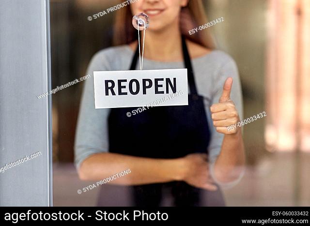 woman with reopen banner on door showing thumbs up