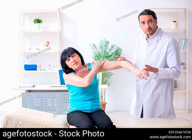 The young male doctor examining old female patient