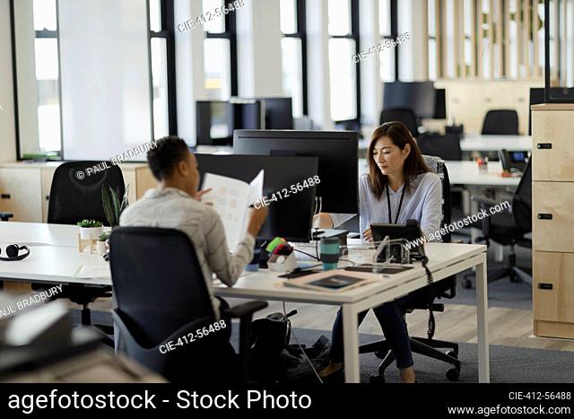 Businesswomen working at computers in open plan office