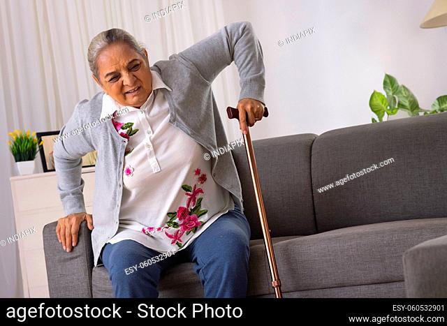 Senior woman trying to stand alone with the help of walking stick