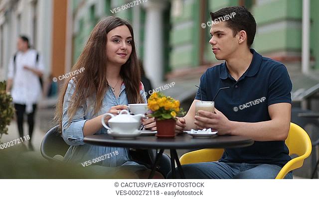 Dating couple relaxing together in street cafe