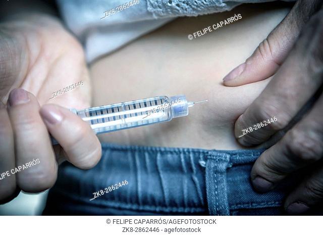 medicine diabetes glycemia health care and people concept - close up of woman with syringe making insulin injection to himself at home