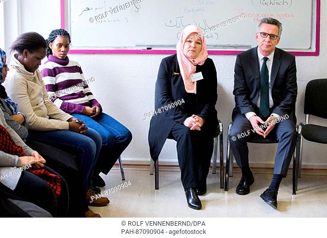German Minister of the Interior Thomas de Maiziere (CDU) sits next to course instructor Erika Theissen in a secondary modern school course of the muslim Family...