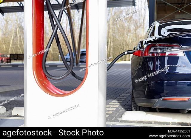Dark blue Tesla Model S at a charging station in Germany