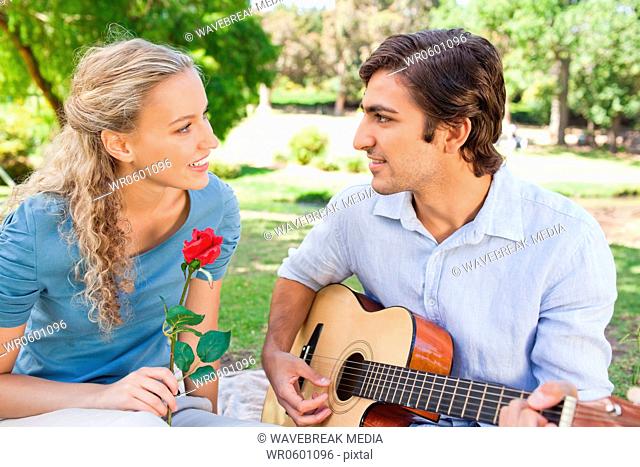 Woman listening to her boyfriend playing the guitar