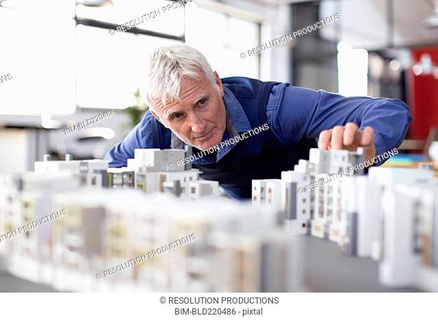 Caucasian architect examining architectural model in office