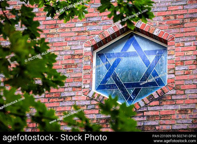 09 October 2023, Mecklenburg-Western Pomerania, Schwerin: The Star of David can be seen in a window of the synagogue. The newly built synagogue stands in a...