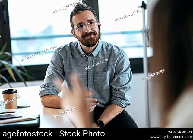 Smiling businessman discussing with colleague office