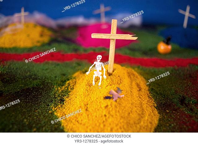 A paper skeleton decorates a tomb made of painted sand and wooden crosses as part of an altar ahead of Day of the Dead celebrations in Mexico City