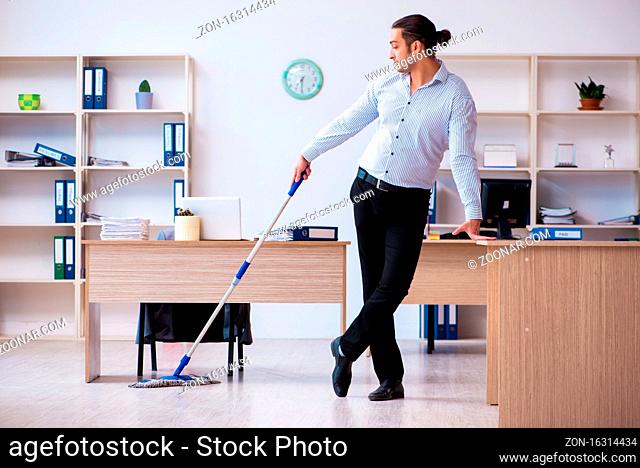 Young employee businessman cleaning office during pandemic