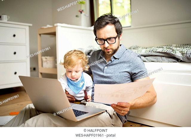Father with his little son working from home