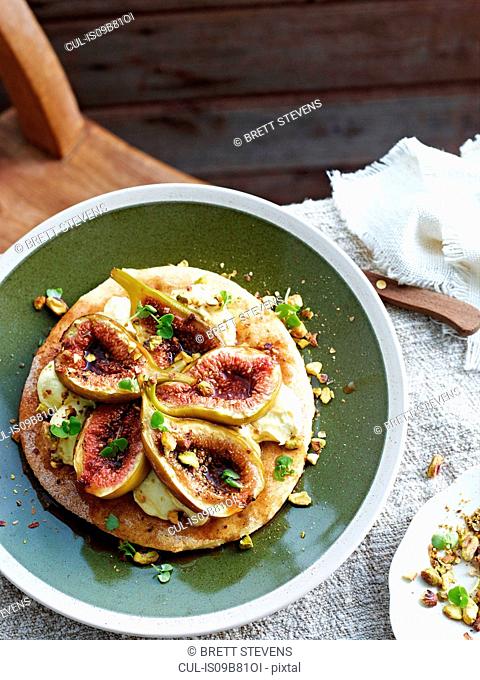Fig and mascarpone pizza on plate, elevated view