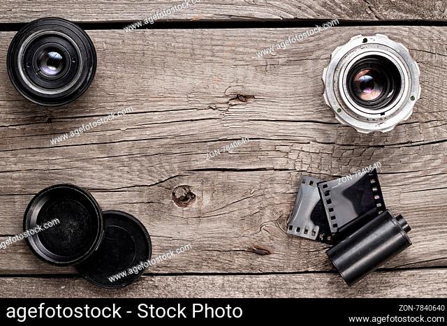 retro camera lenses and negative film on wooden table