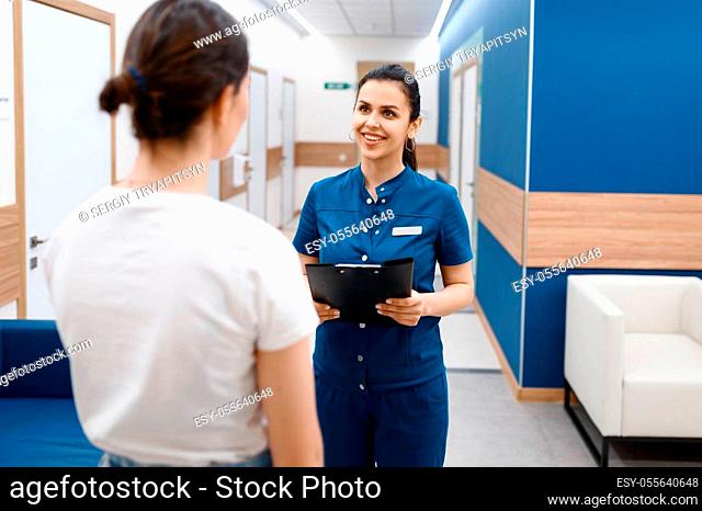 Female surgeon talks with patient in clinic hall, surgery. Doctor in uniform, medical worker, medicine and health, professional healthcare in hospital