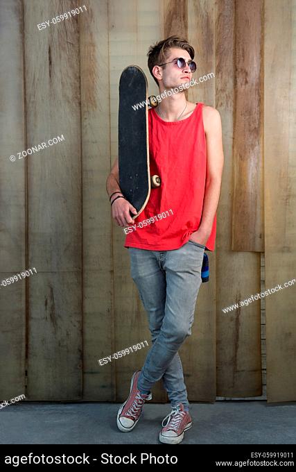 cool street skateboarder with sunglasses in front of iron wall